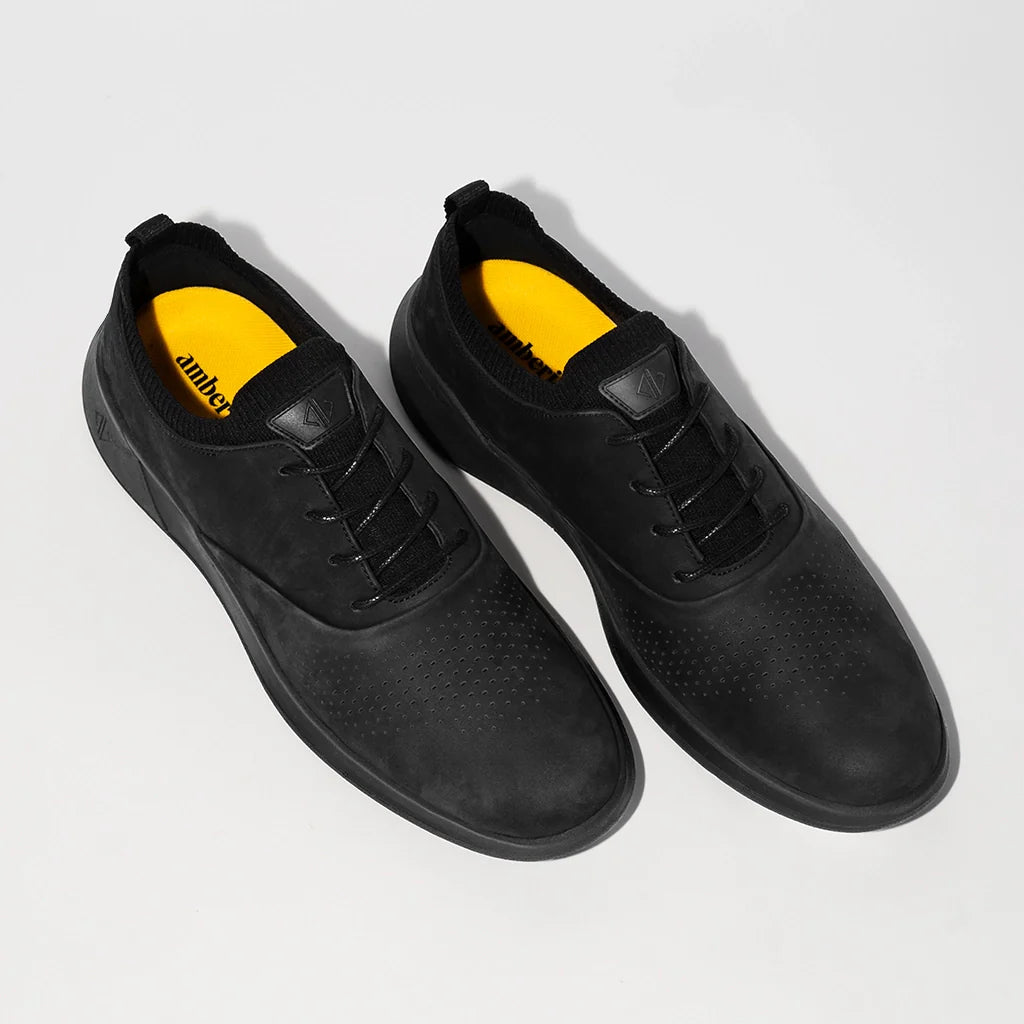 Black shoes with yellow accents on a light gray background