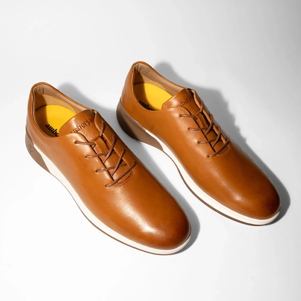 Pair of brown leather shoes on a light gray background