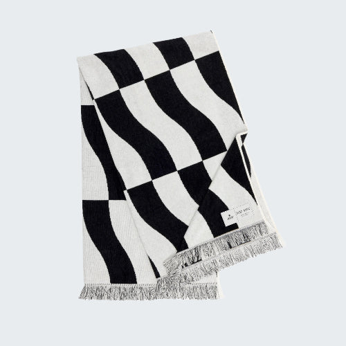 Black and white checkered scarf with fringes on a white background