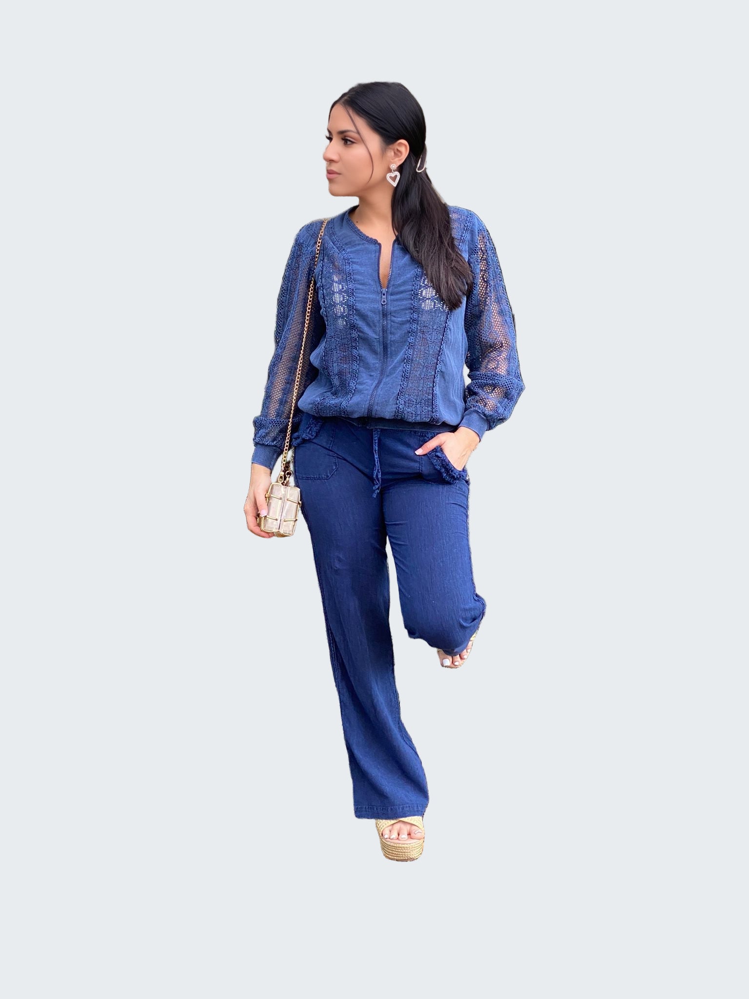 Woman in a blue outfit standing in a forest setting