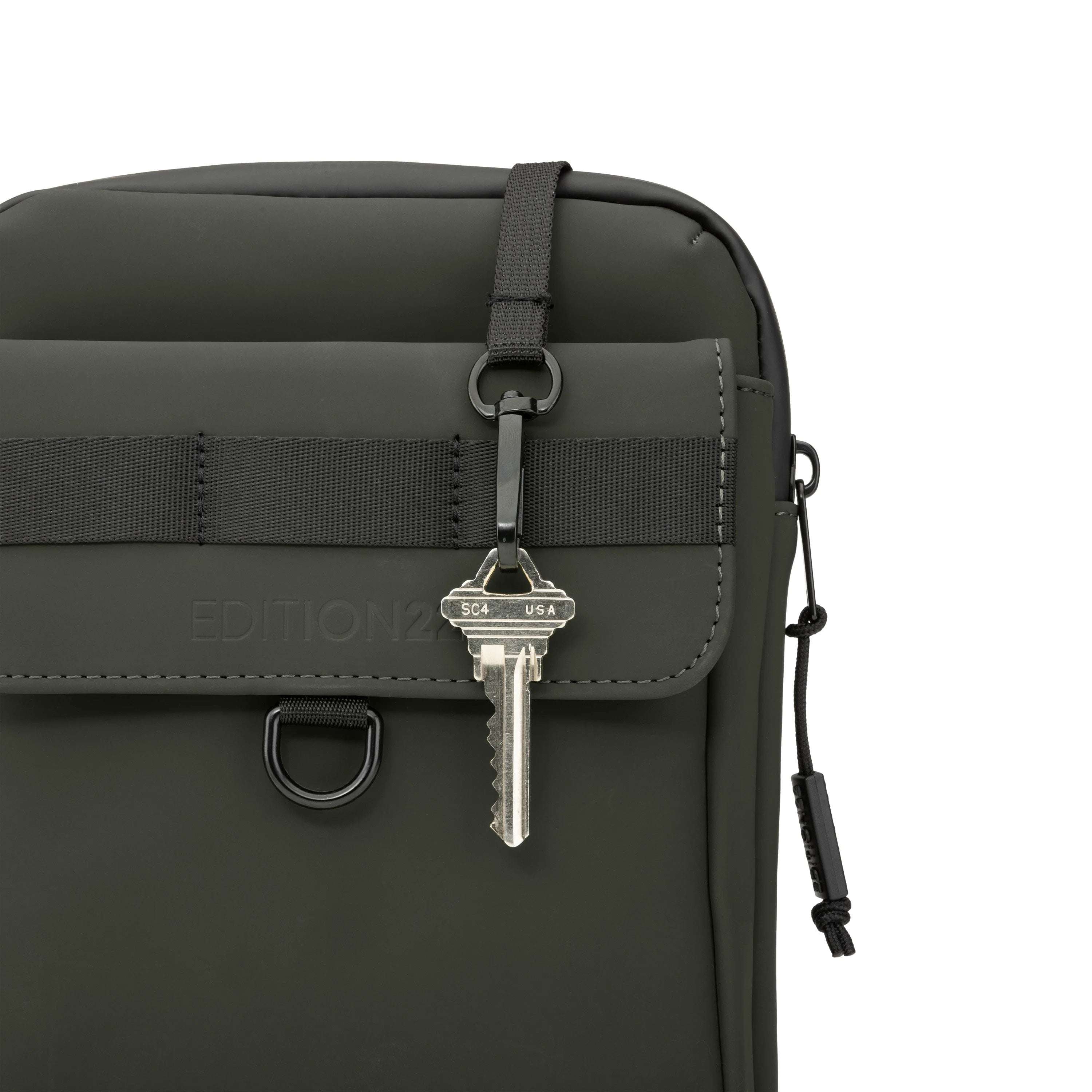 Black bag with a key attached on a white background
