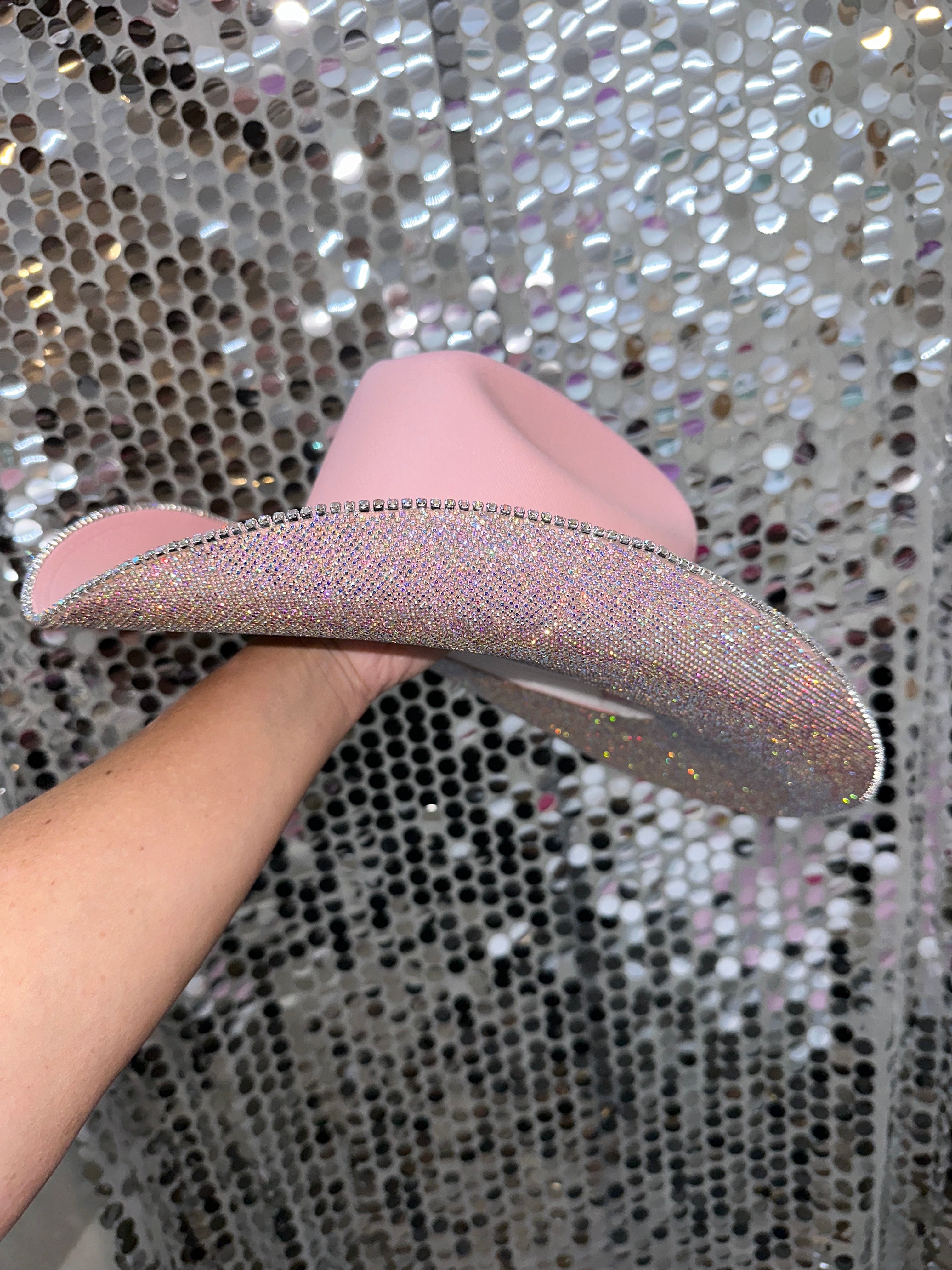Pink sandal with glittery strap on a sequin background