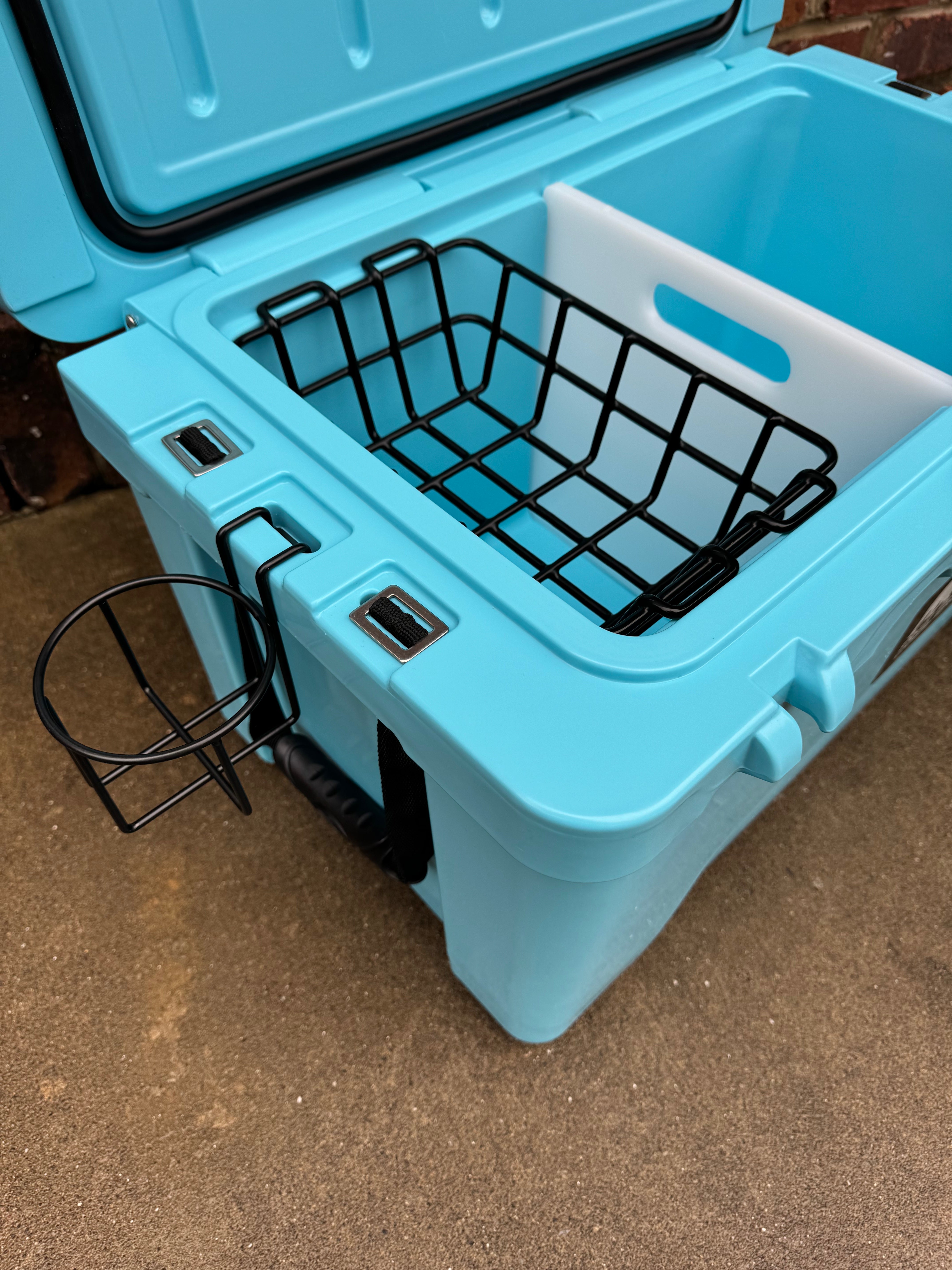 Blue cooler with a black wire basket on a brown surface