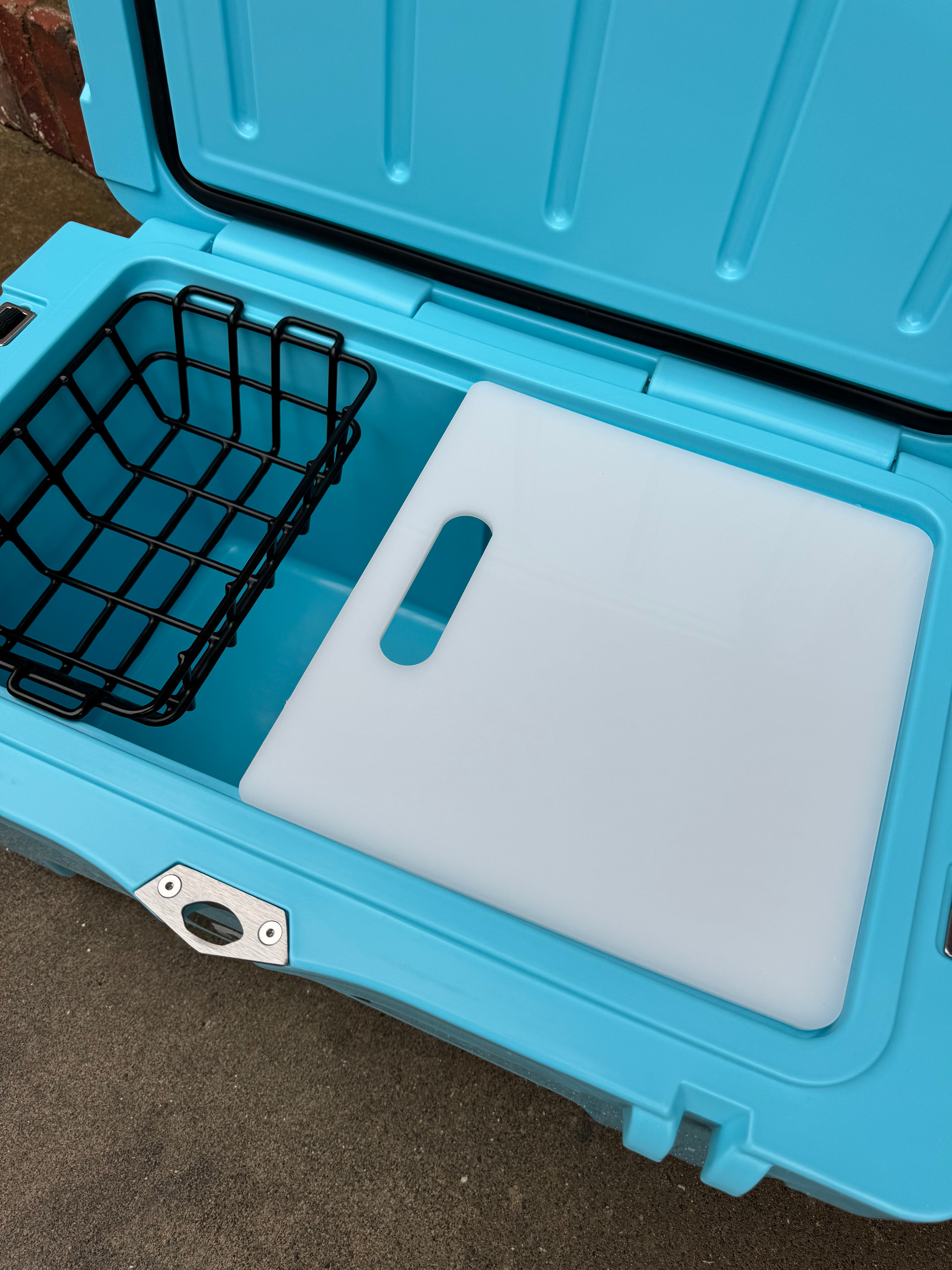 Blue cooler with a cutting board and wire basket on a carpeted floor