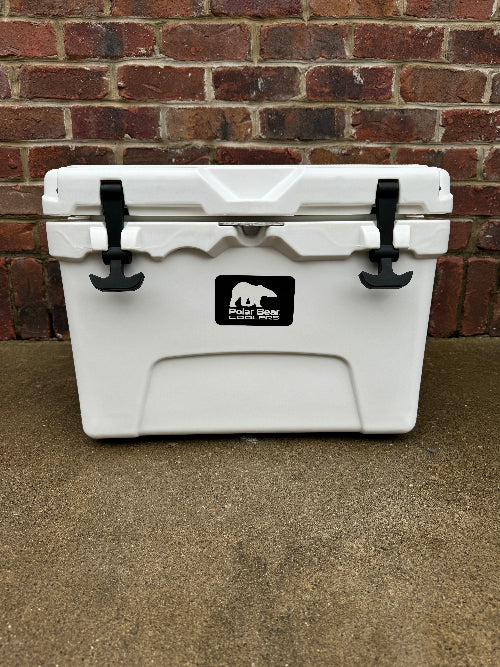 White cooler with a logo on it, placed against a brick wall.