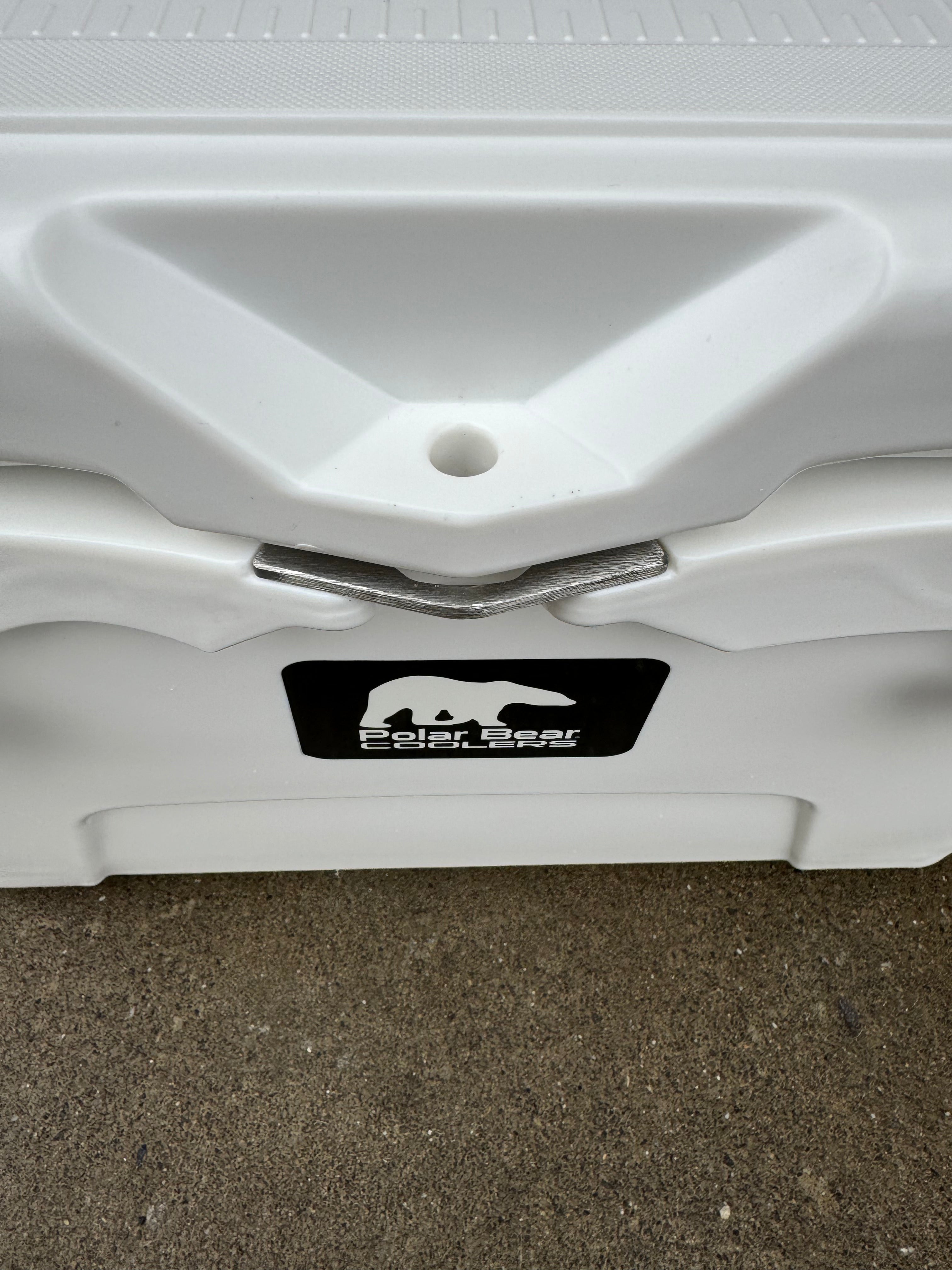 Close-up of a white cooler with a visible brand logo on a concrete surface