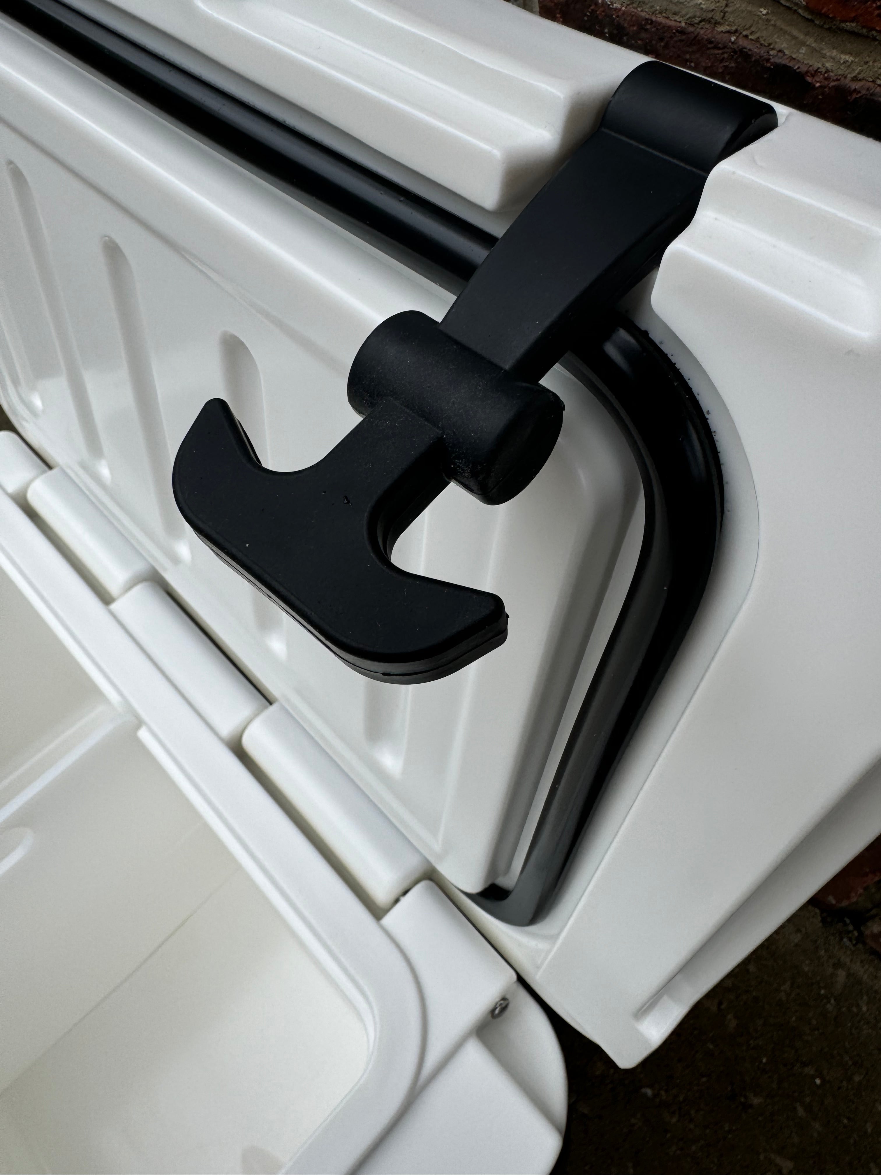 Close-up of a black handle on a white cooler box