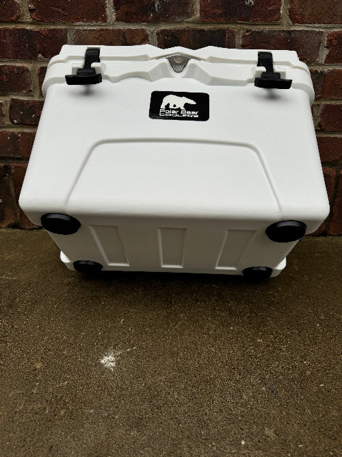 White cooler with a logo on a concrete surface and brick wall background