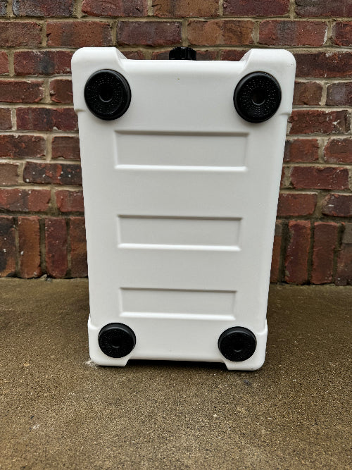 White plastic step stool with black wheels against a brick wall.
