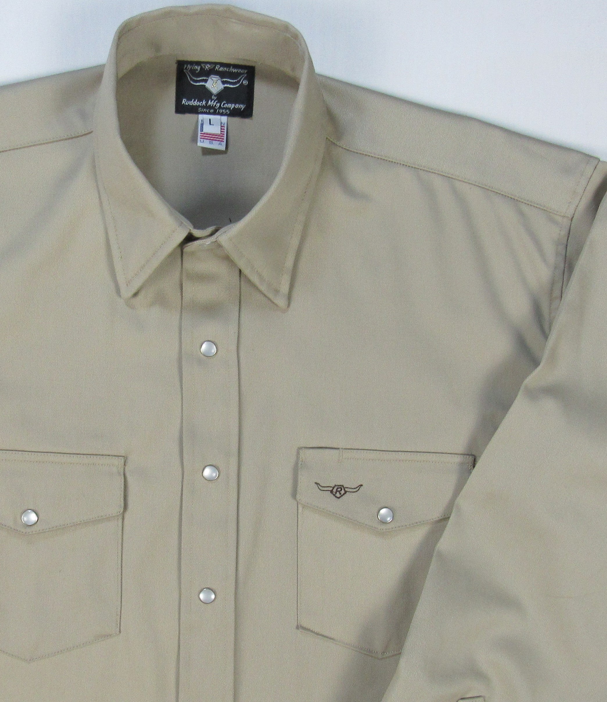Beige long-sleeve shirt with silver buttons on a white background