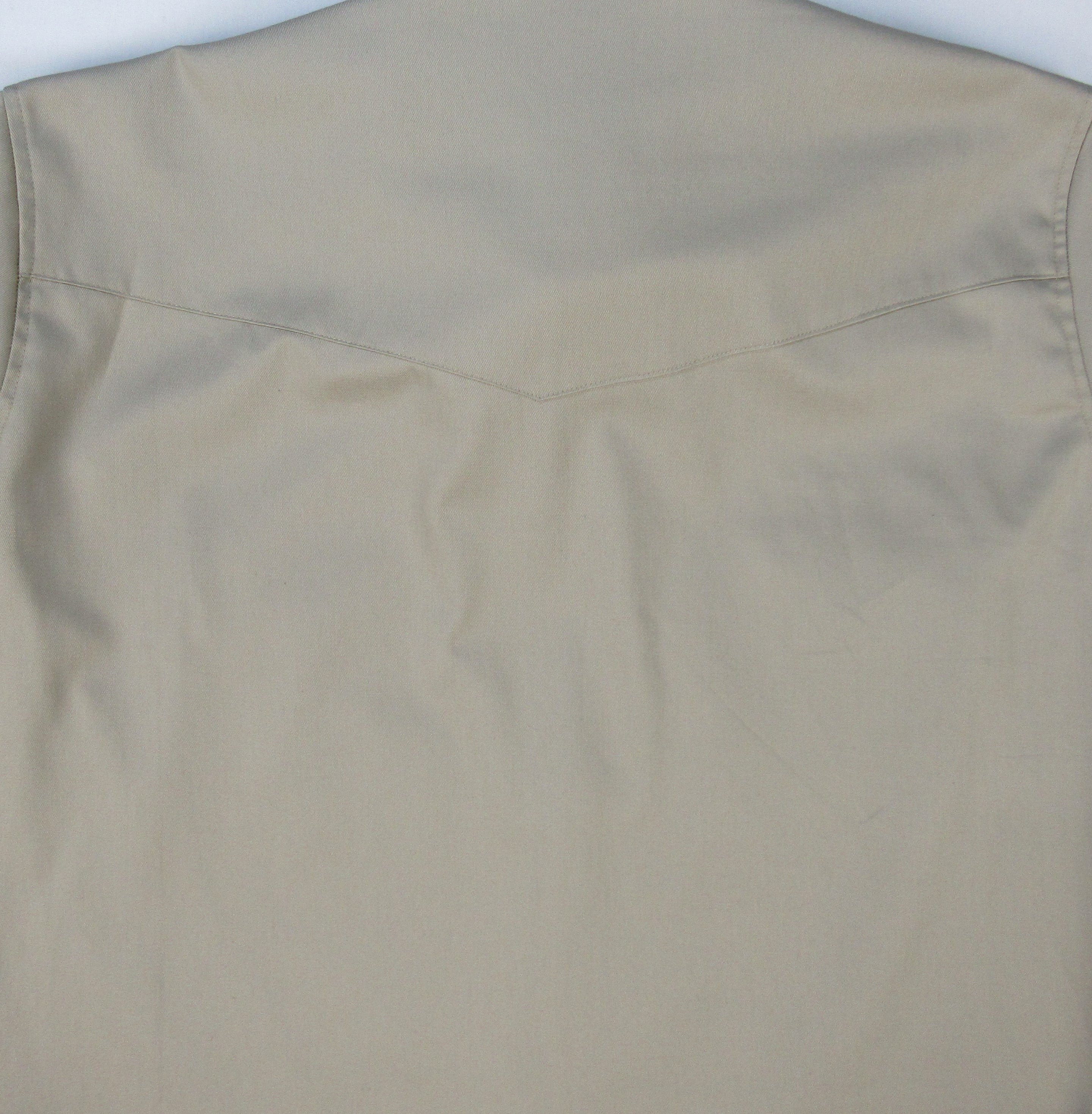 Close-up of beige pants with a plain background