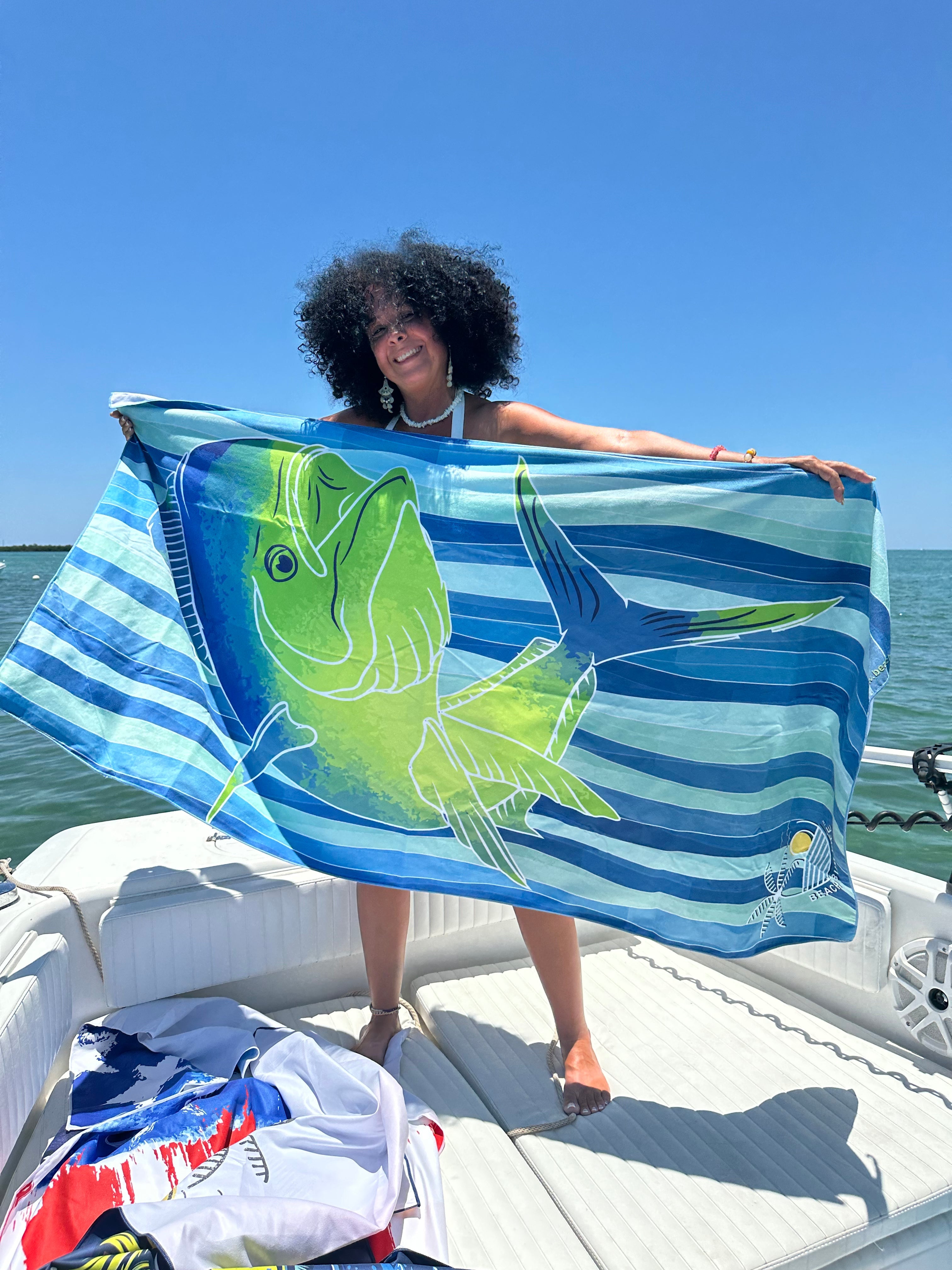 Person holding a colorful towel with a fish design on a boat