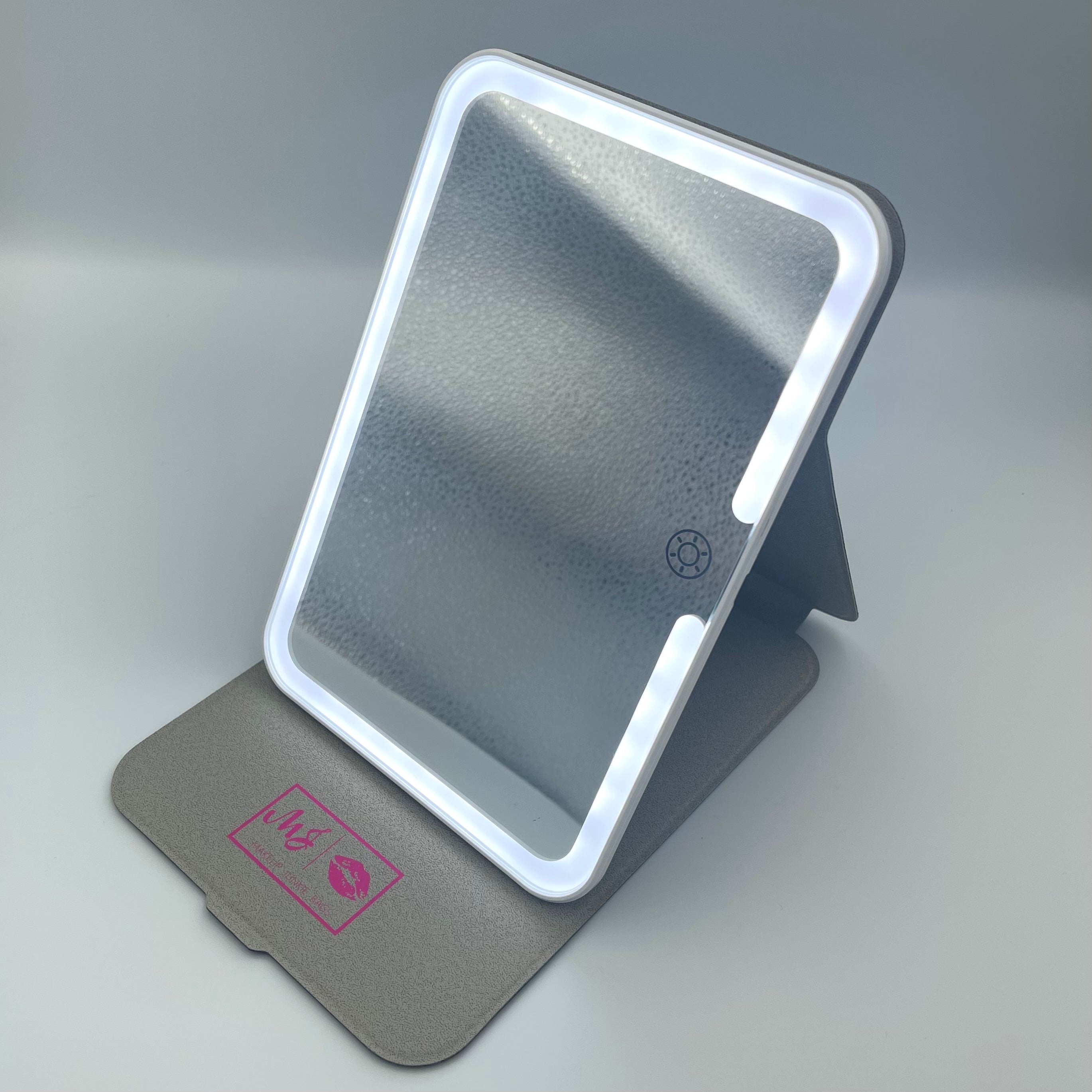 Foldable mirror with a gray stand on a light gray background