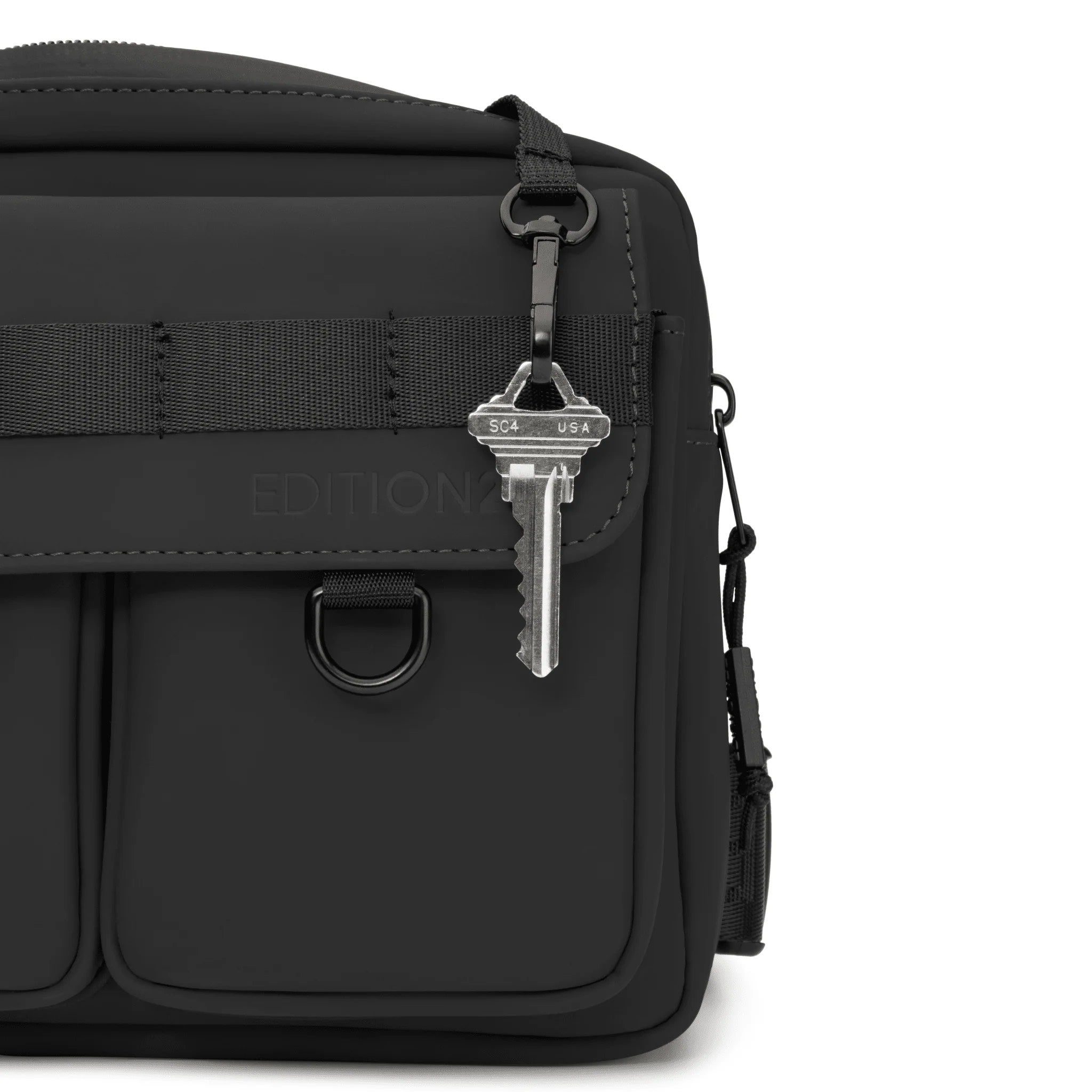 Black bag with a keychain attached on a white background