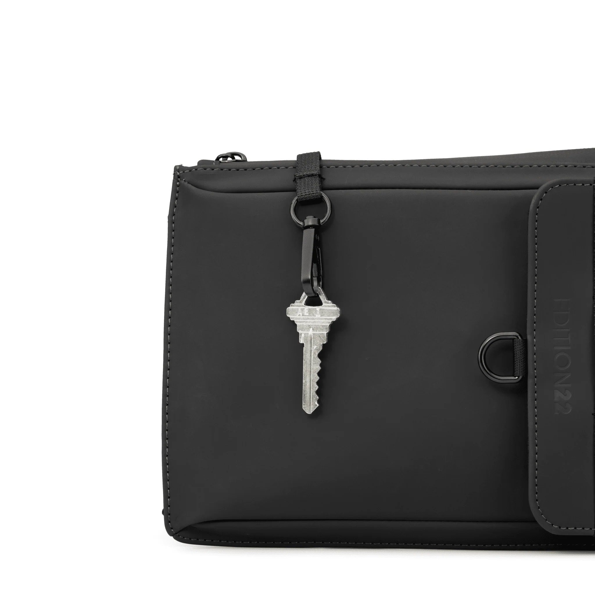 Black leather pouch with a key attached on a white background