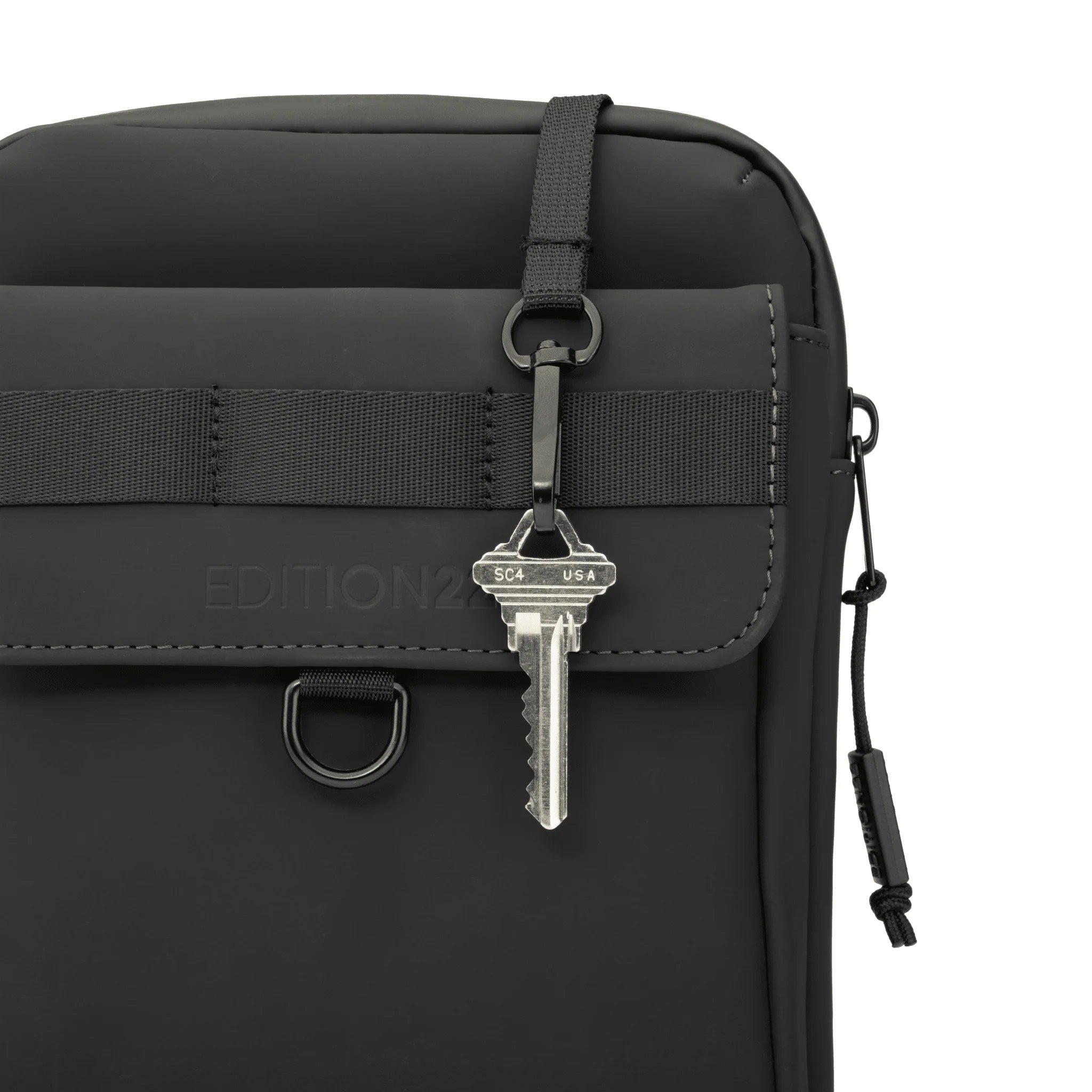 Black bag with a key attached on a white background