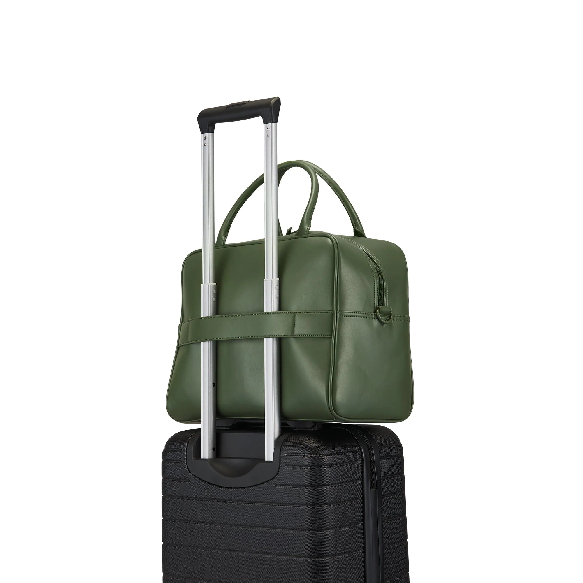 Green bag with a handle on top of a black suitcase on a white background
