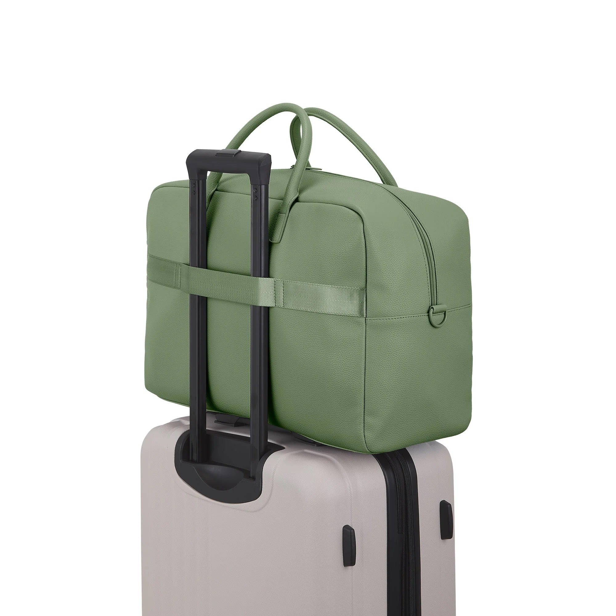 Green travel bag with handle on top of a suitcase against a white background