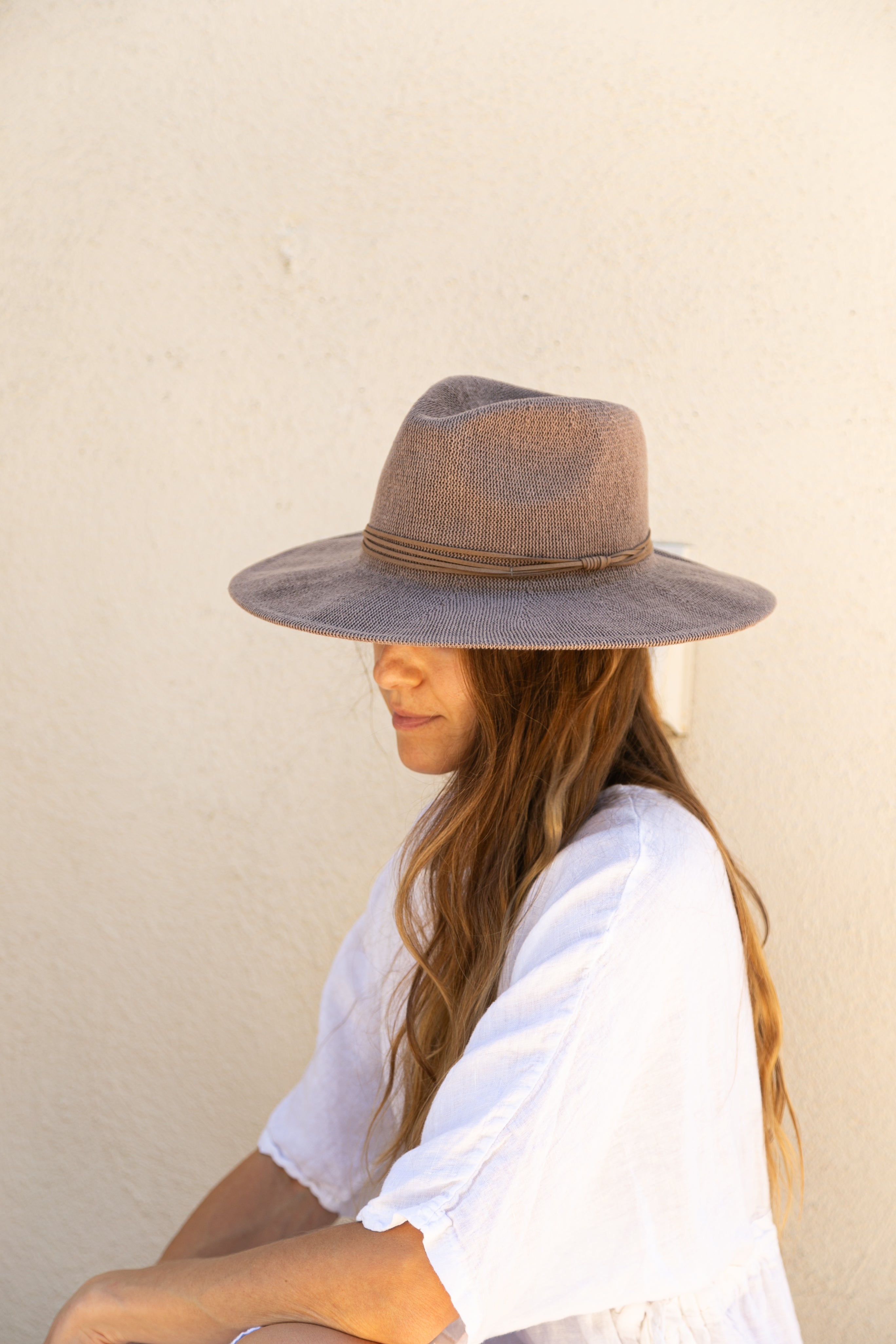 Person wearing a wide-brimmed hat against a plain background