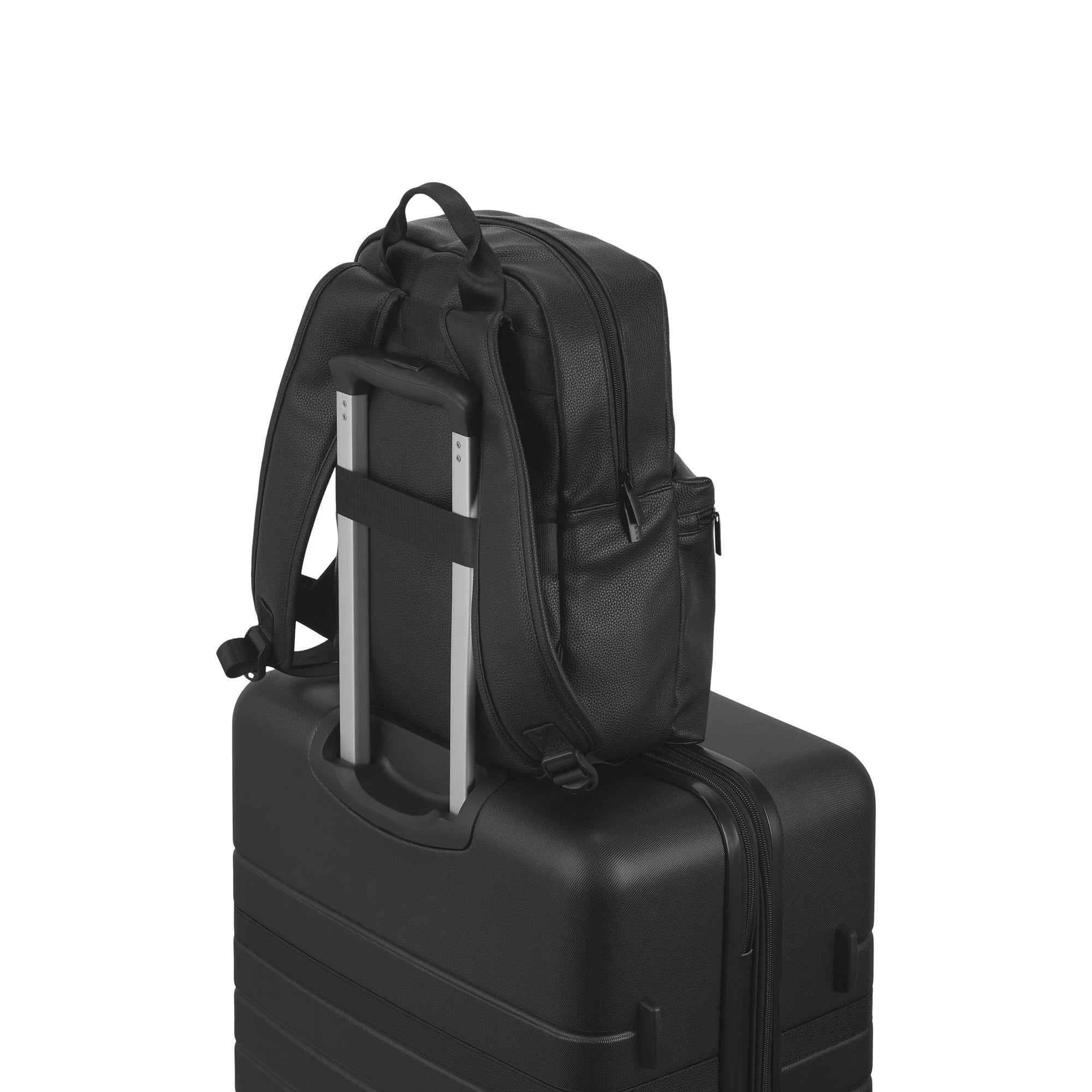 Black backpack on top of a black suitcase on a white background