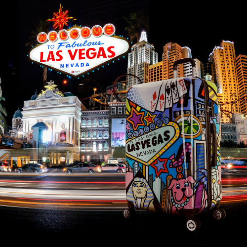 Colorful suitcase with Las Vegas design in front of the Las Vegas sign at night.