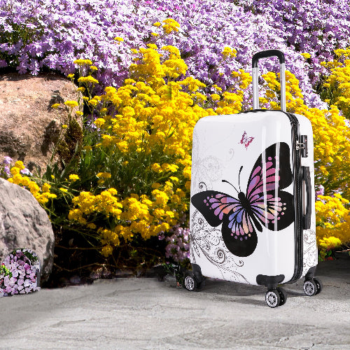 White suitcase with butterfly design in a garden setting