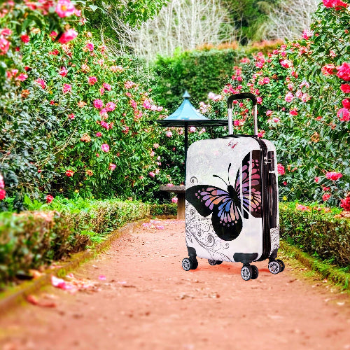 Suitcase with butterfly design in a garden setting
