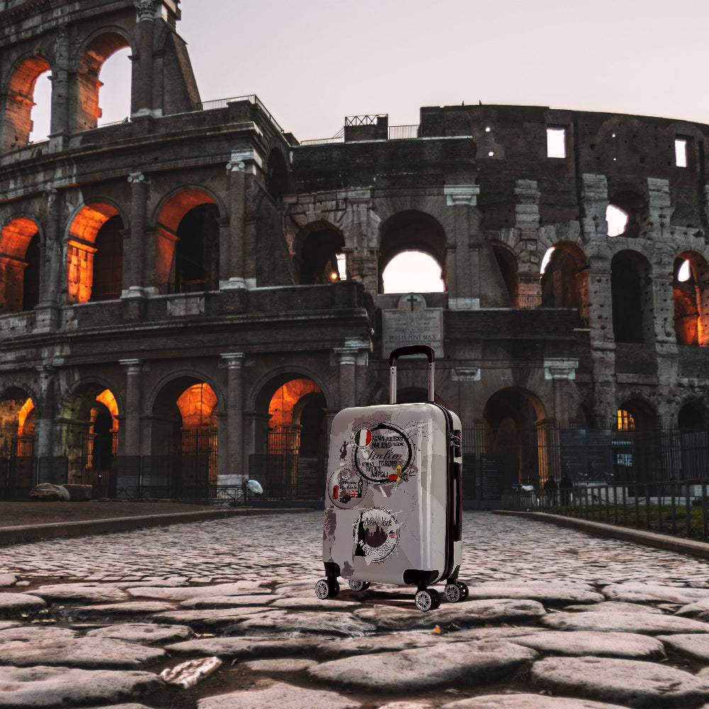 Suitcase with stickers in front of the Colosseum at dusk