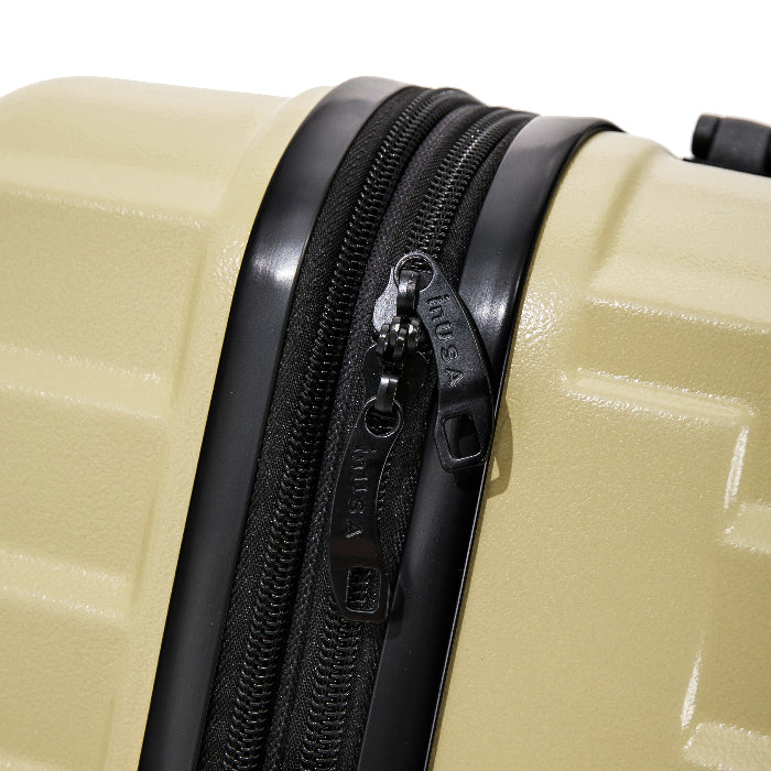 Close-up of a beige suitcase with a black zipper, featuring the brand name 'J World' on the zipper pull.