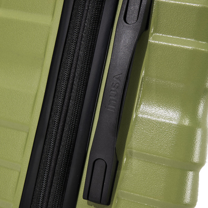 Close-up of a green suitcase with a black zipper and handle, featuring the brand 'InUSA'.