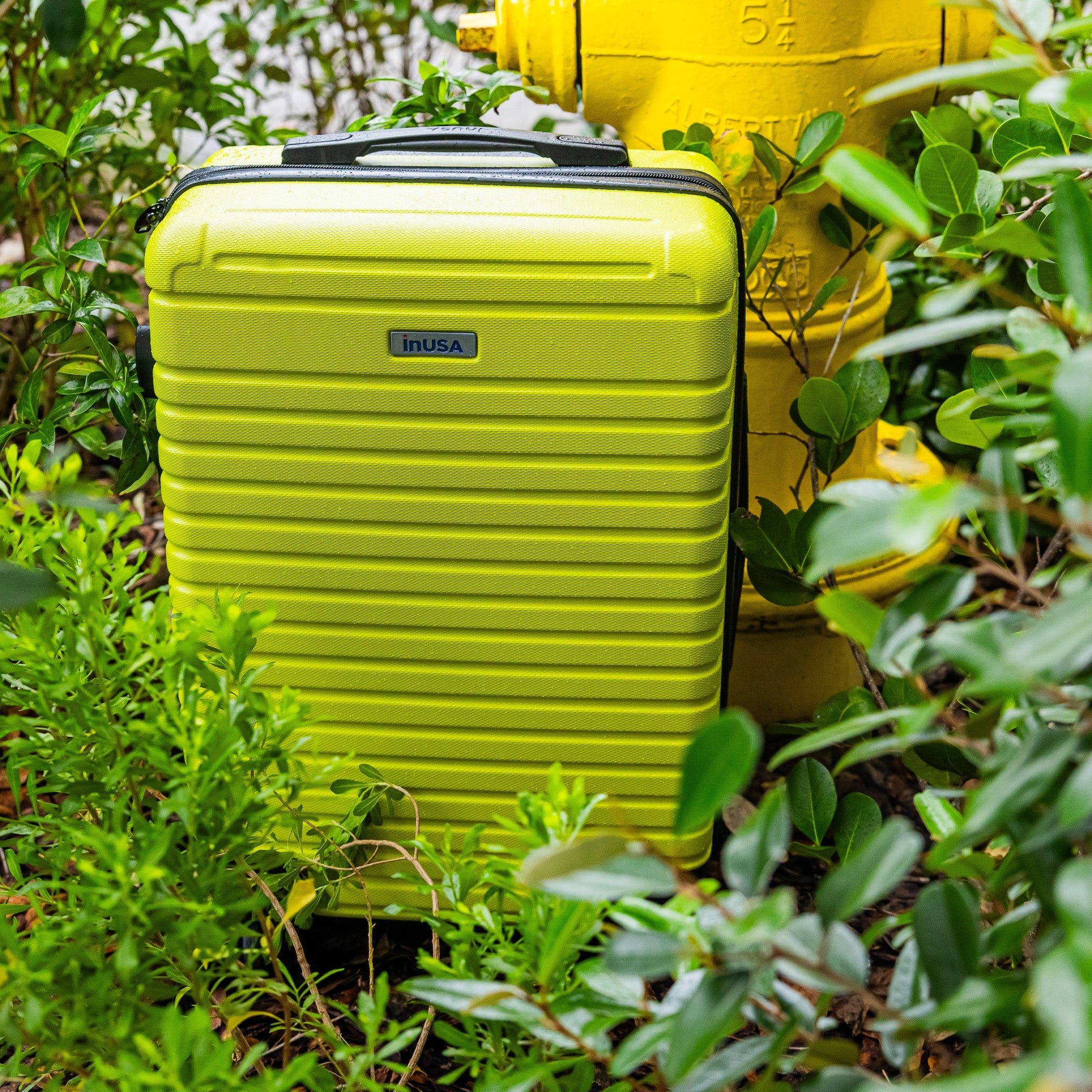 Green suitcase with 'inUSA' logo on a green background