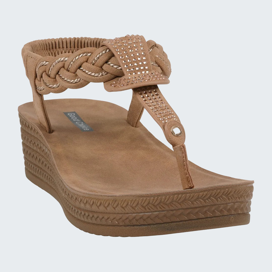 Tan wedge sandal with braided design on a white background
