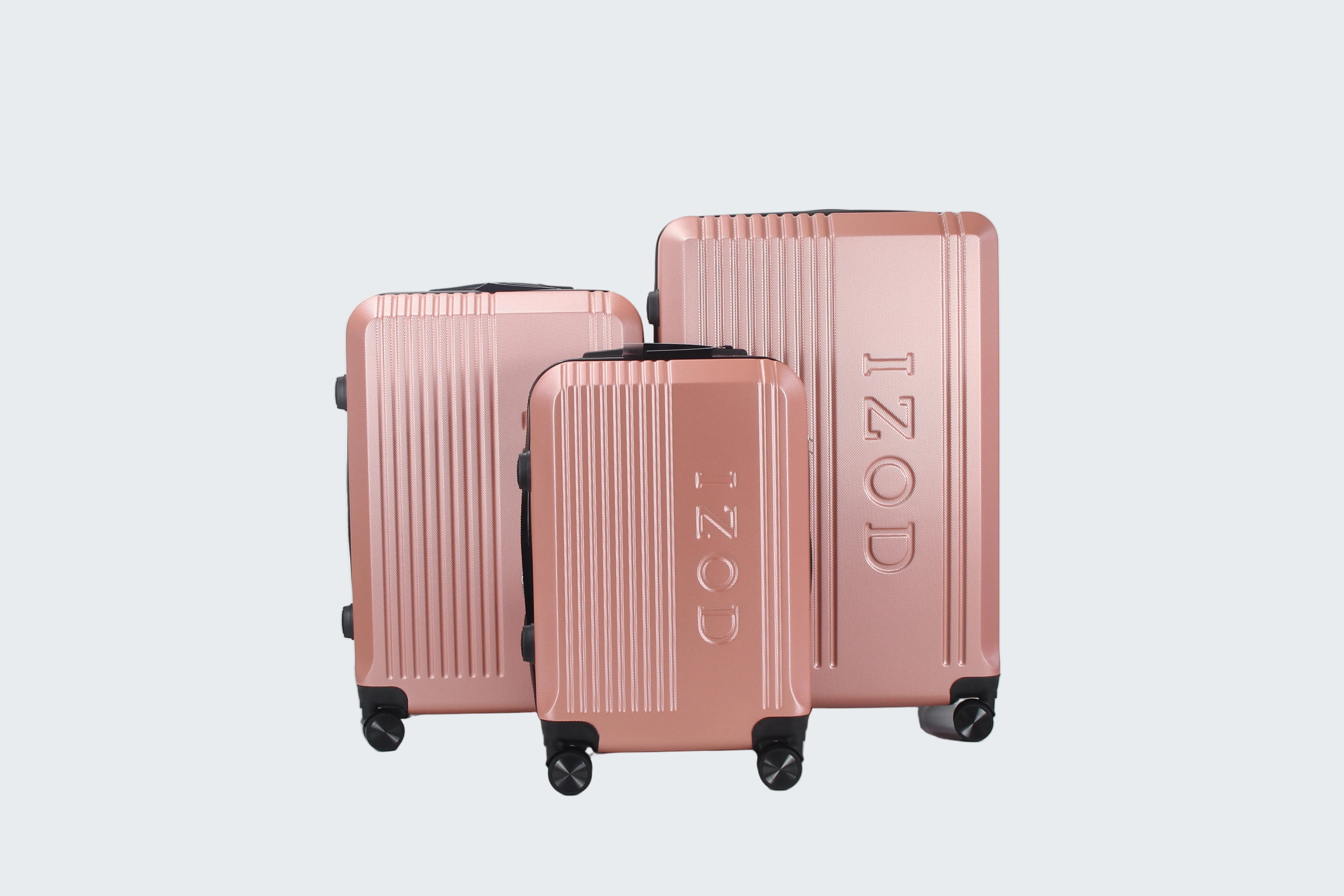 Set of three rose gold suitcases with 'IZOD' branding on a white background