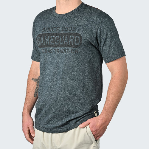 Person wearing a gray t-shirt with 'Gameguard Texas Tradition' text on a white background