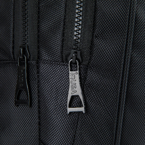 Close-up of a black zipper on a textured surface with 'inUSA' branding.