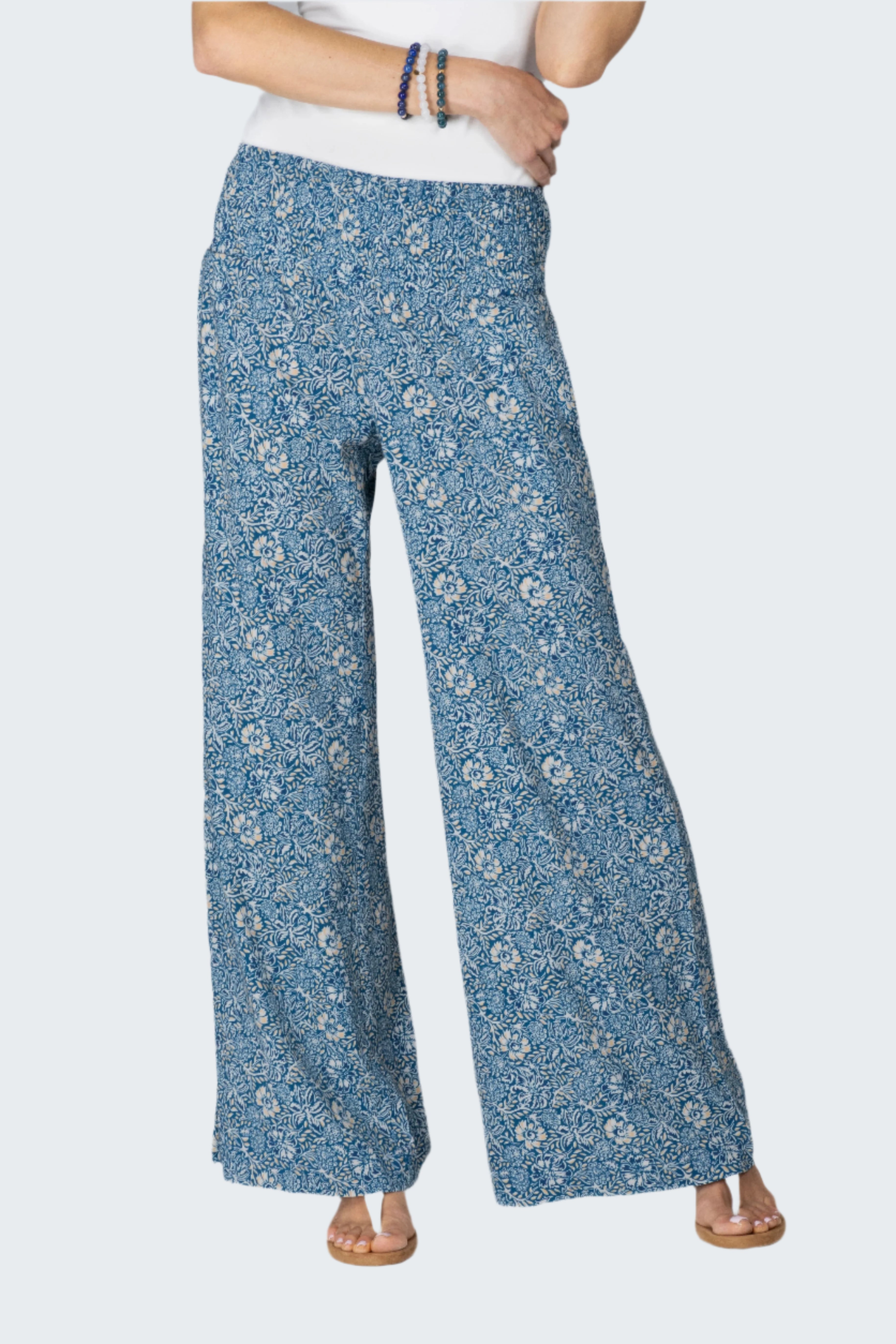 Person wearing blue floral-patterned pants on a white background