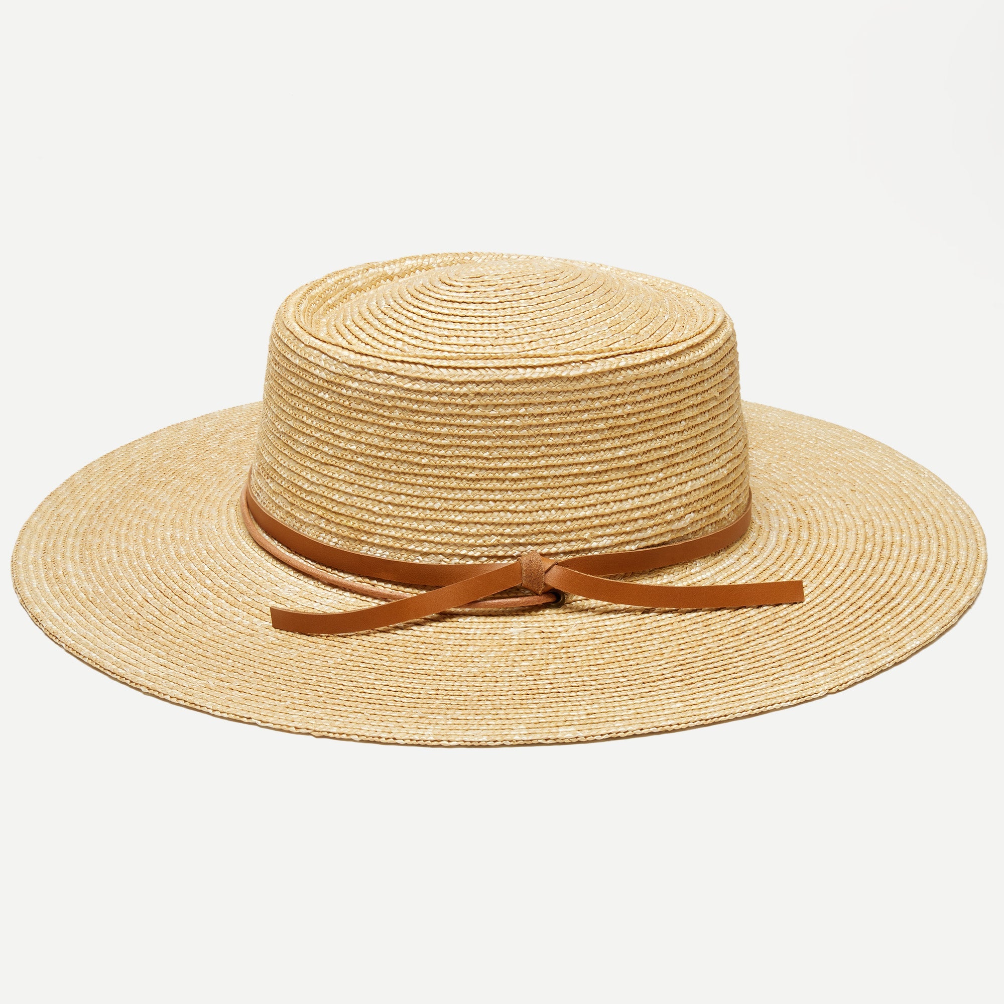 Beige straw hat with a brown ribbon on a white background