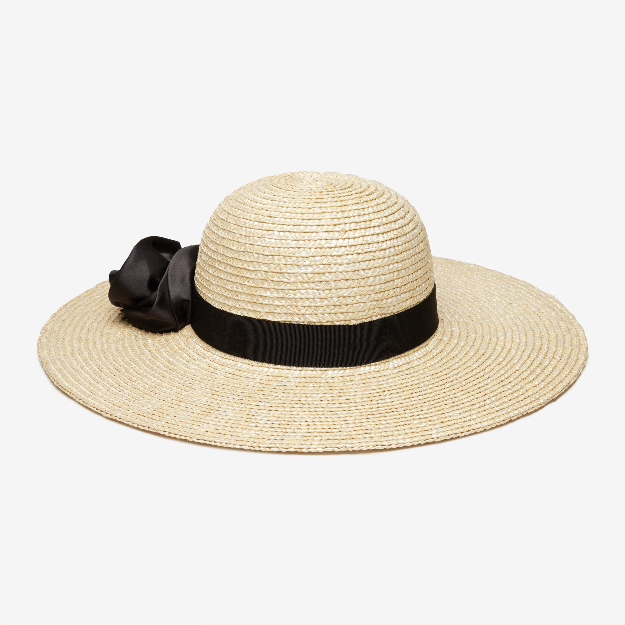 Beige straw hat with a black ribbon and bow on a white background