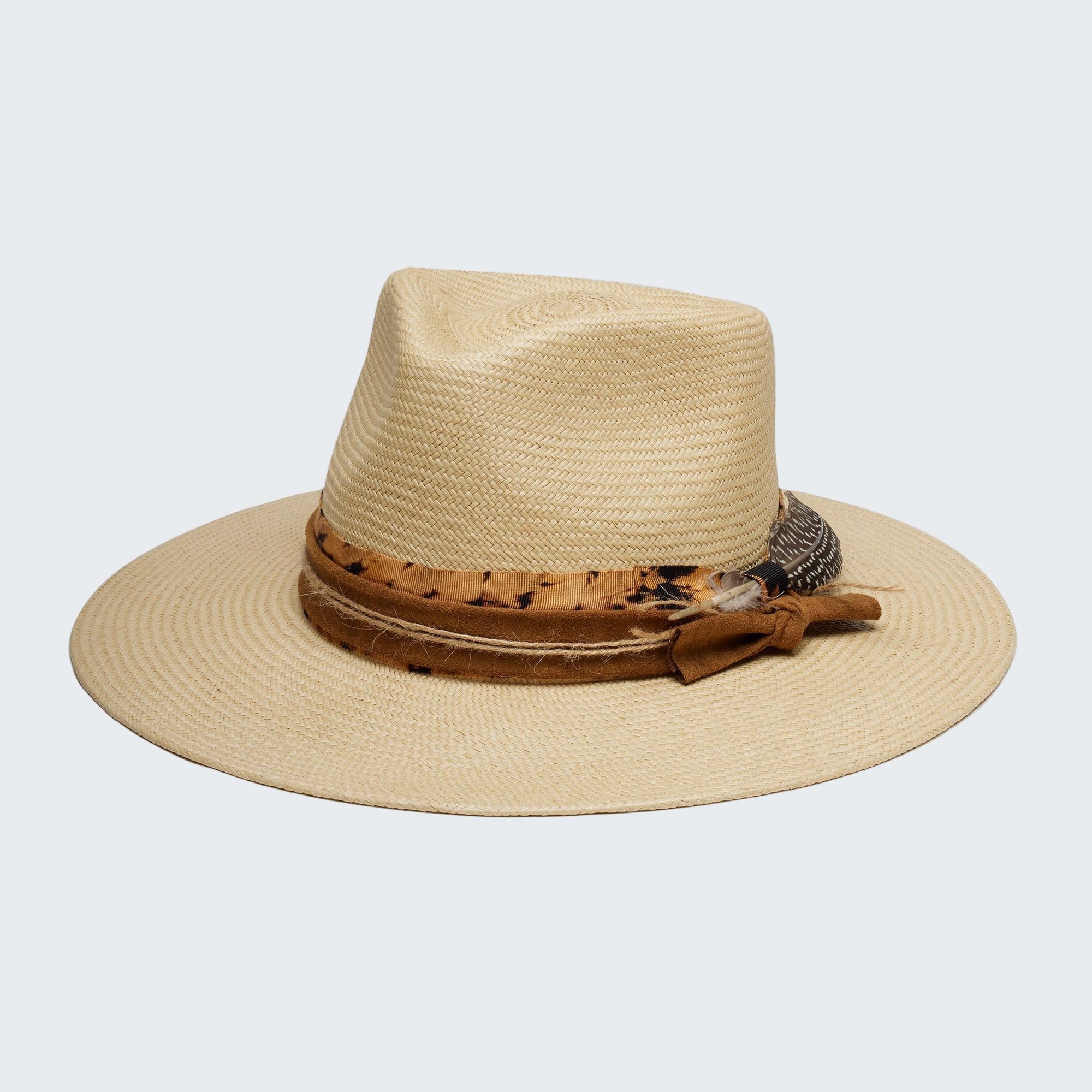 Beige straw hat with a brown band and decorative elements on a white background