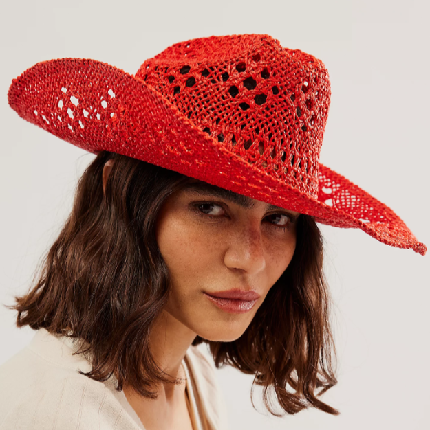 Person wearing a red woven hat against a plain background