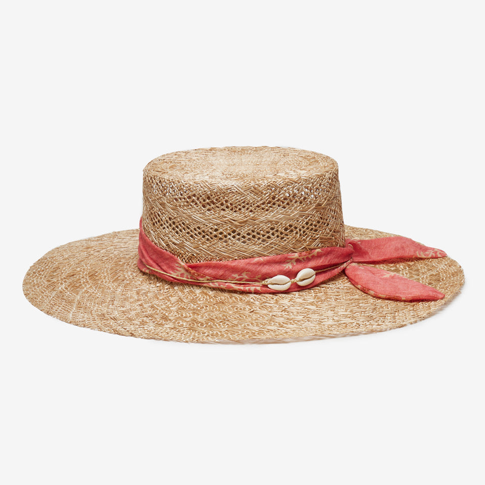 Straw hat with a pink band and shell decorations on a white background
