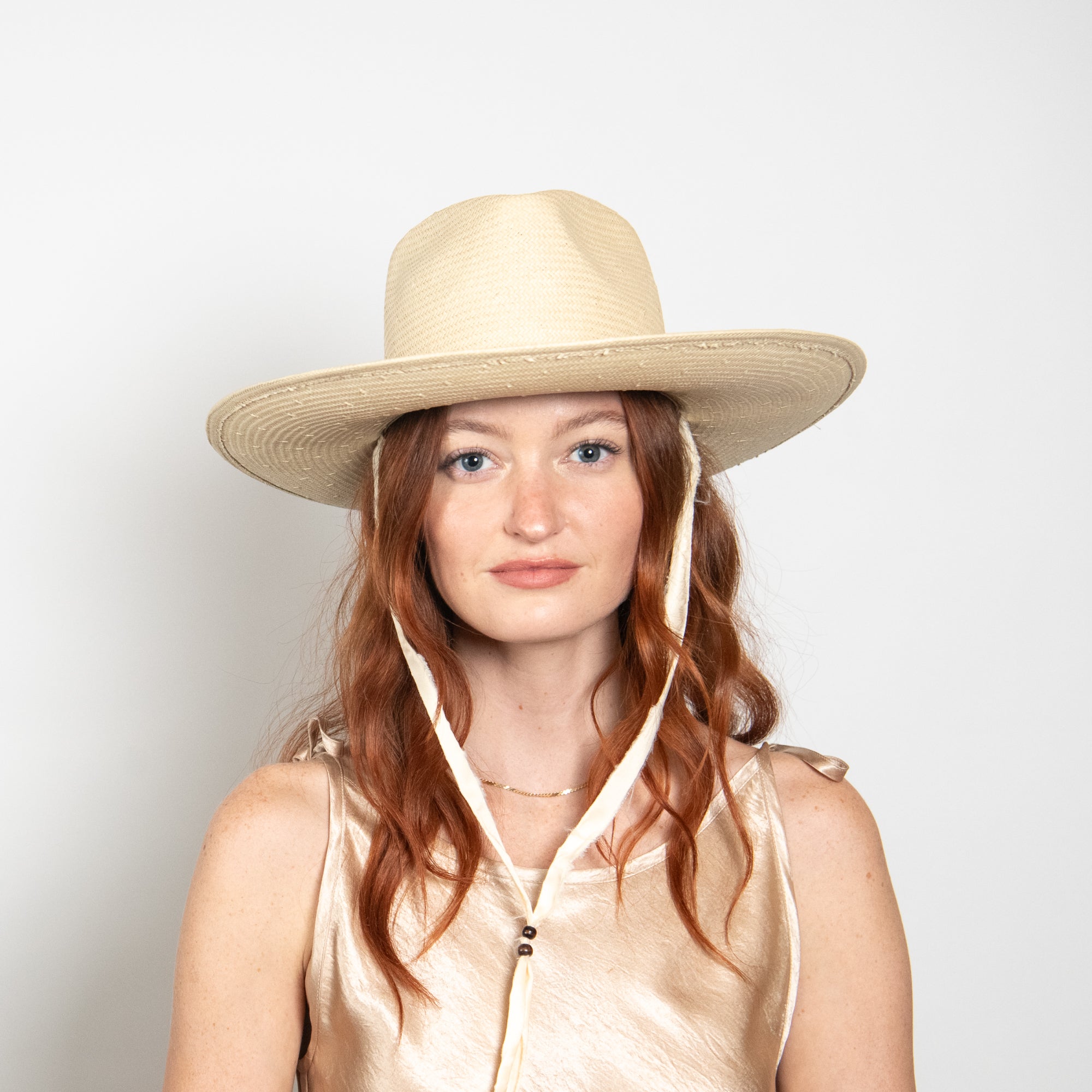 Woman wearing a beige hat with a white background