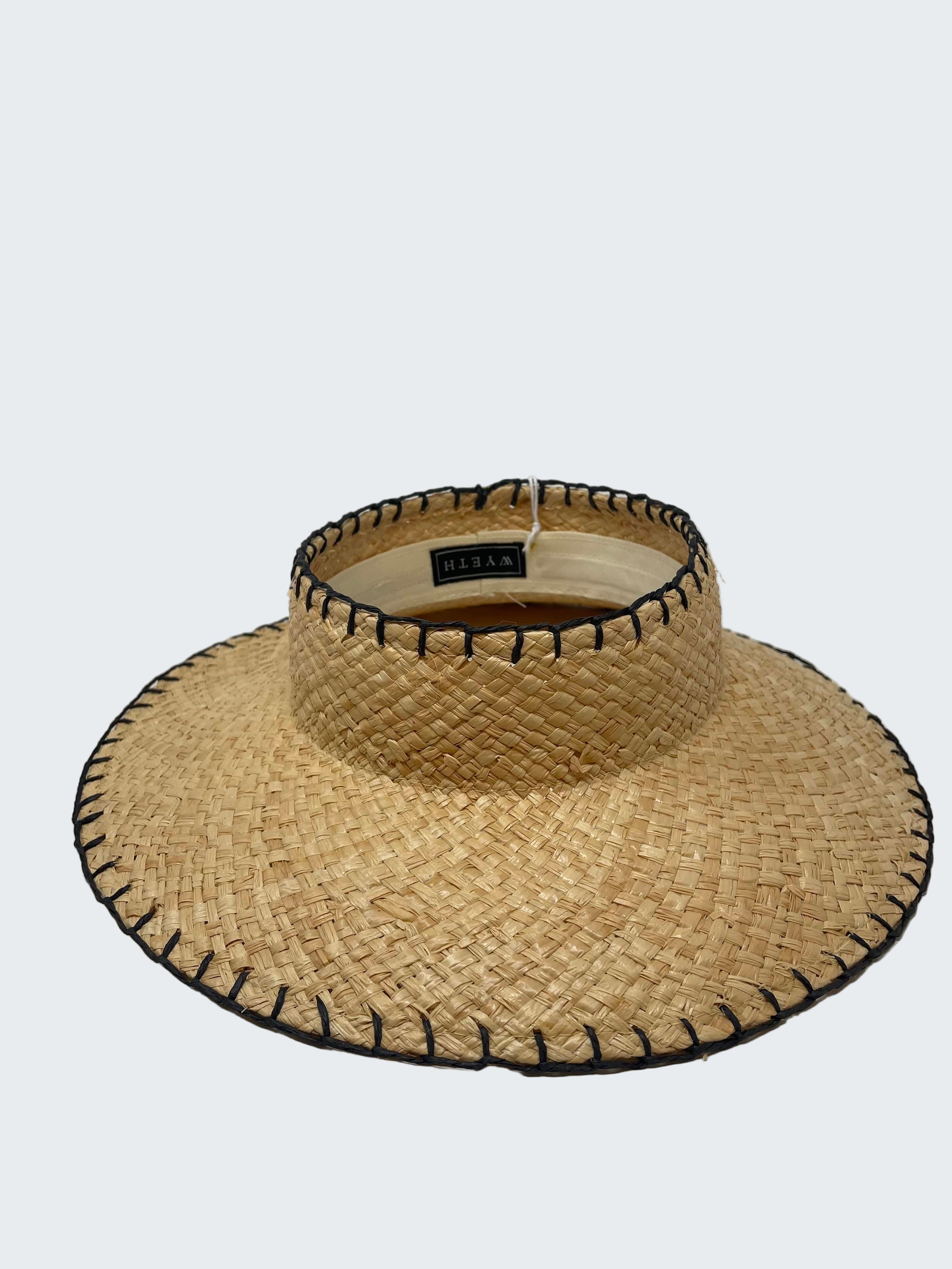 Straw visor hat with black trim on a white background