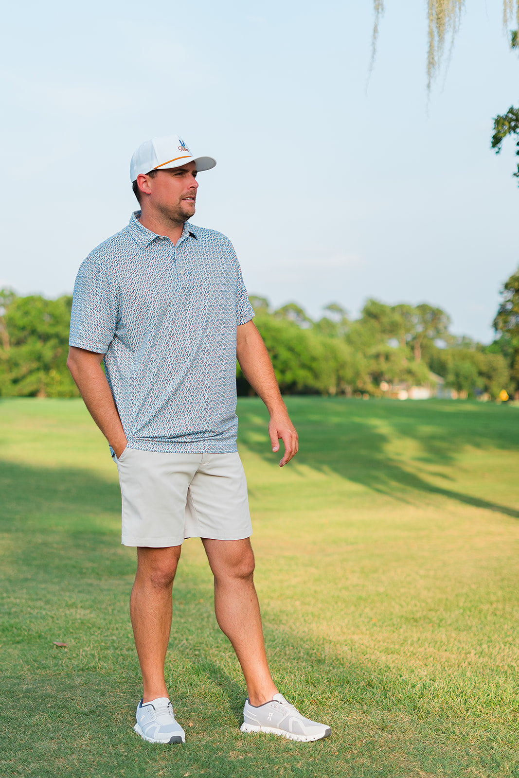 Man in golf attire standing on a golf course
