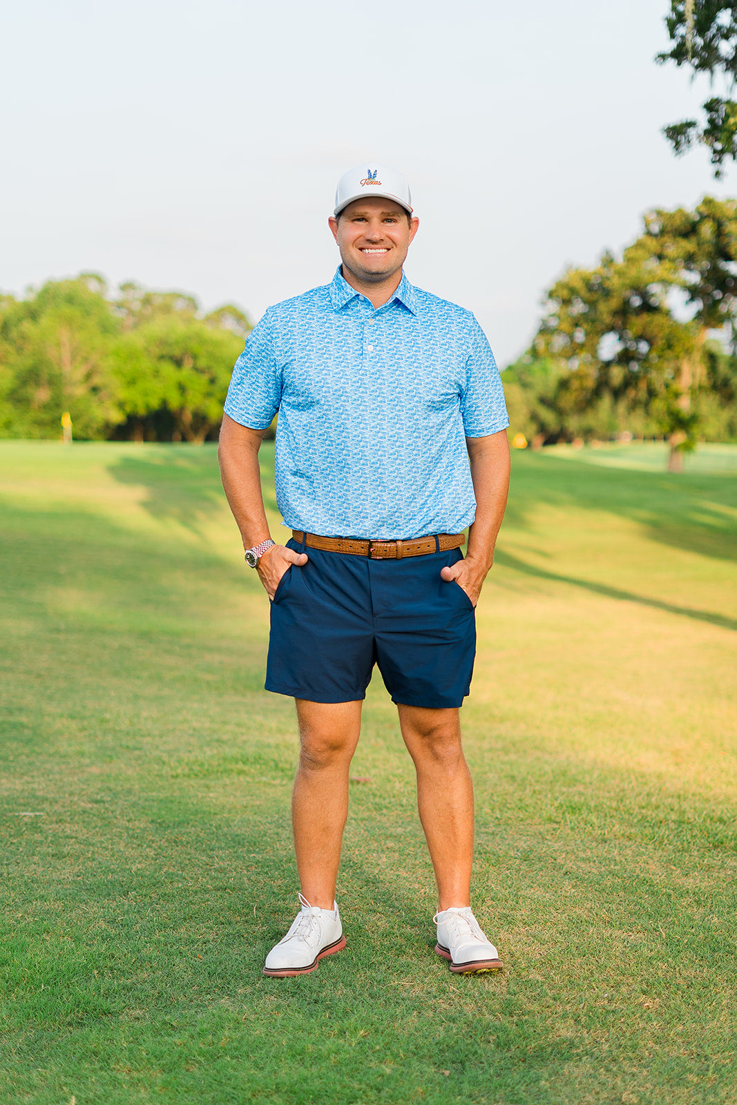 Man in golf attire standing on a golf course