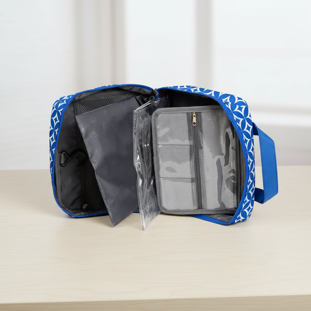 Blue toiletry bag with clear compartments on a white background