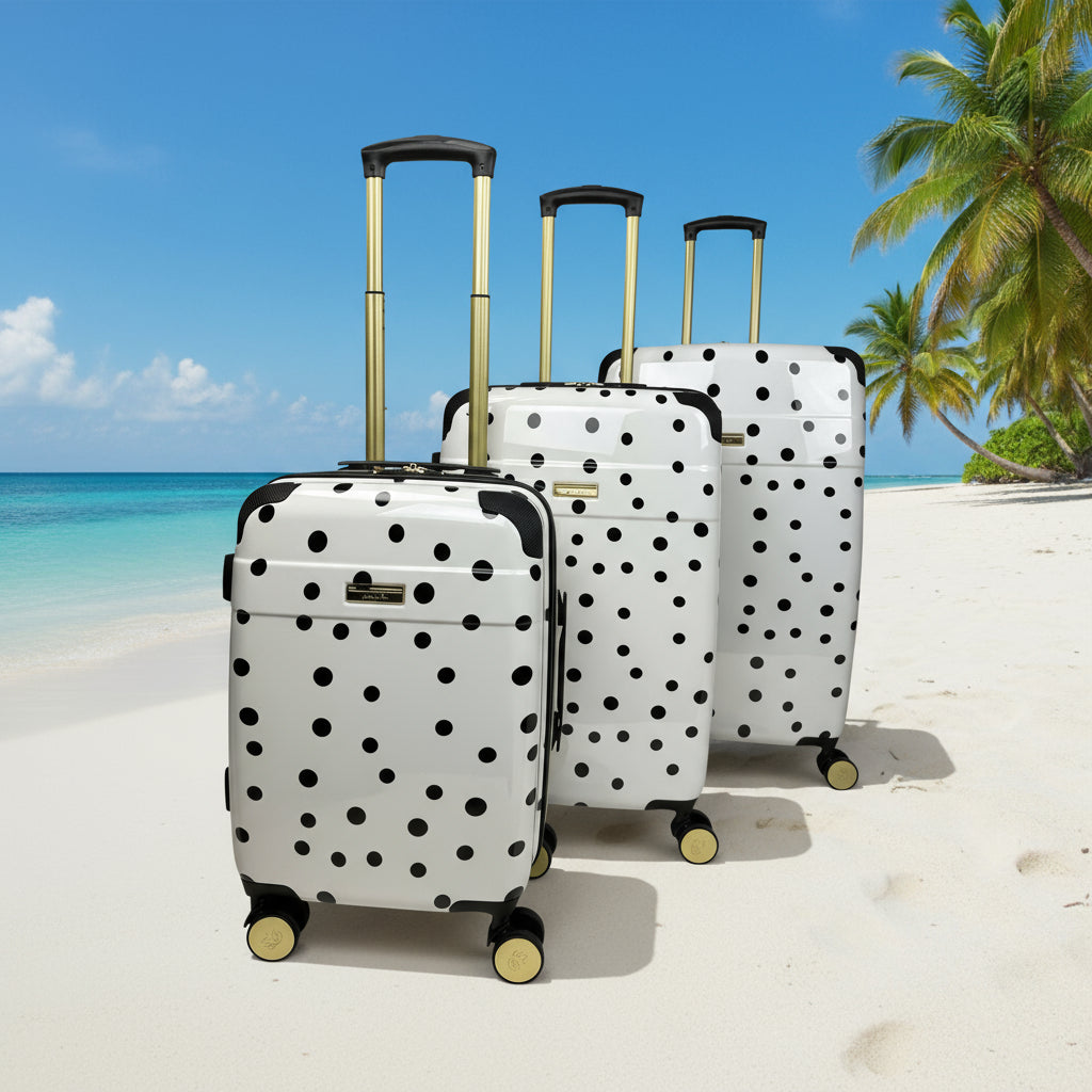 Set of three polka dot suitcases on a white background