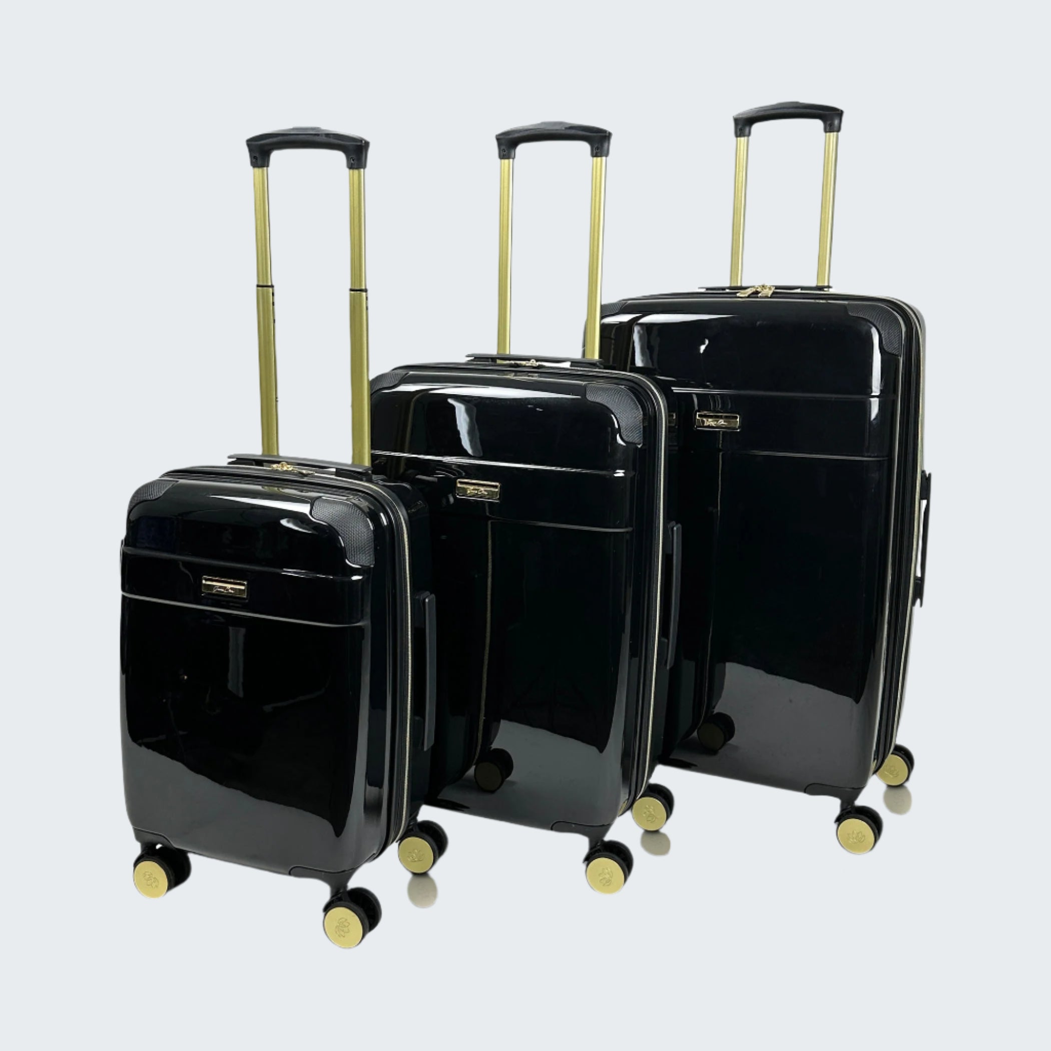Set of black suitcases with gold handles and wheels on a white background