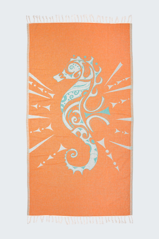 Orange beach towel with a white seahorse design on a white background