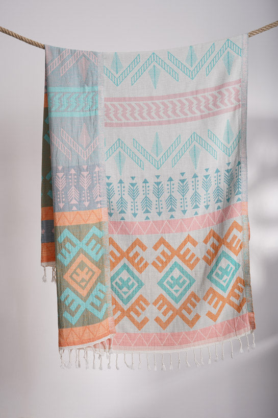 Colorful patterned towel hanging on a line against a white background